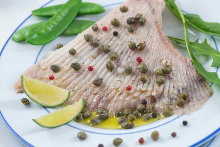 Aile de raie vapeur aux câpres et citron vert, servie avec des légumes verts.