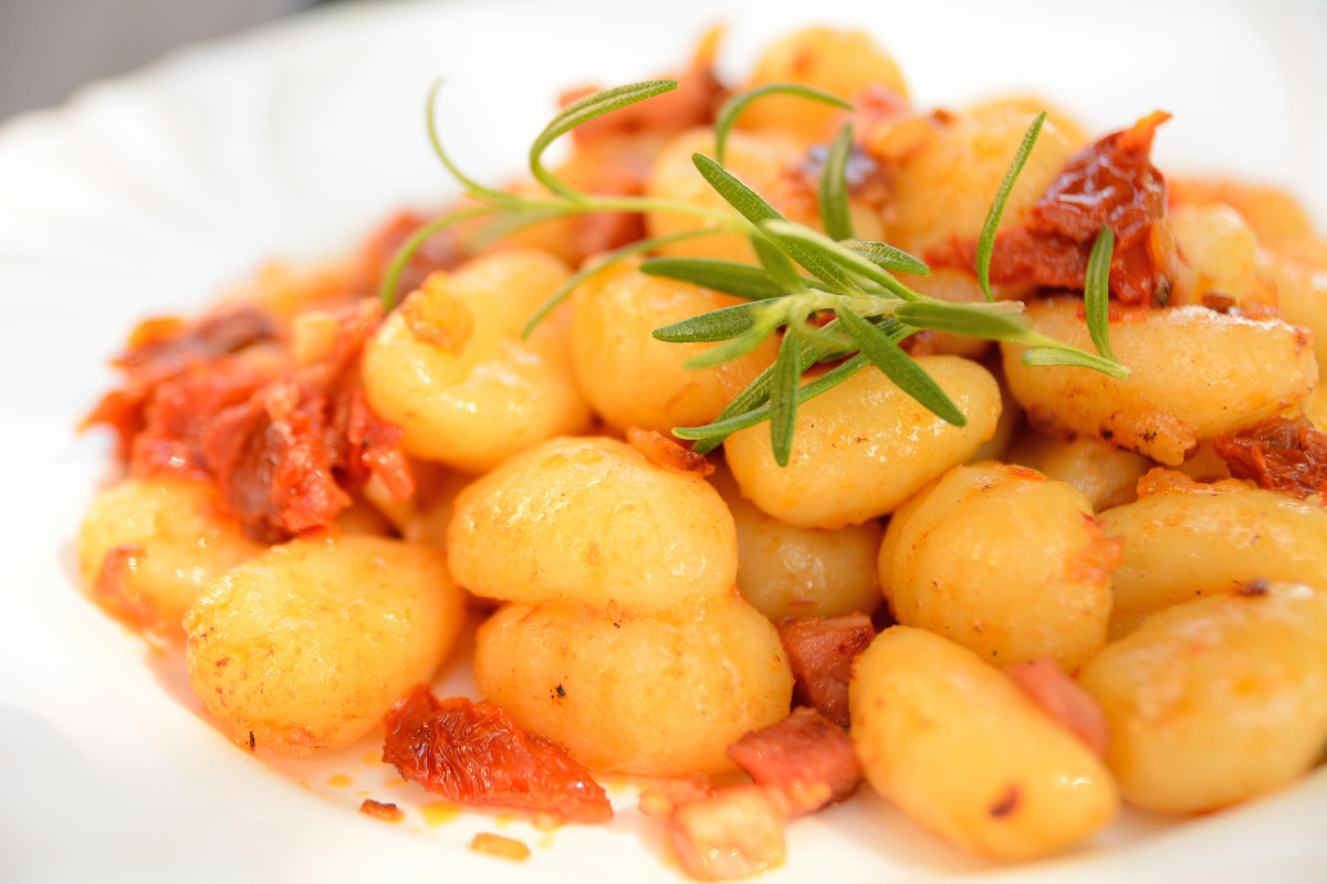 Gnocchis po&ecirc;l&eacute;s aux tomates et oignons d&eacute;cor&eacute;s de romarin.
