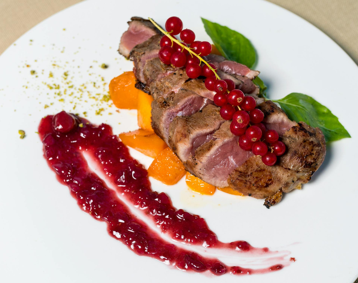 Magret de canard ros&eacute;, servi avec groseilles, abricots et coulis de fruits.