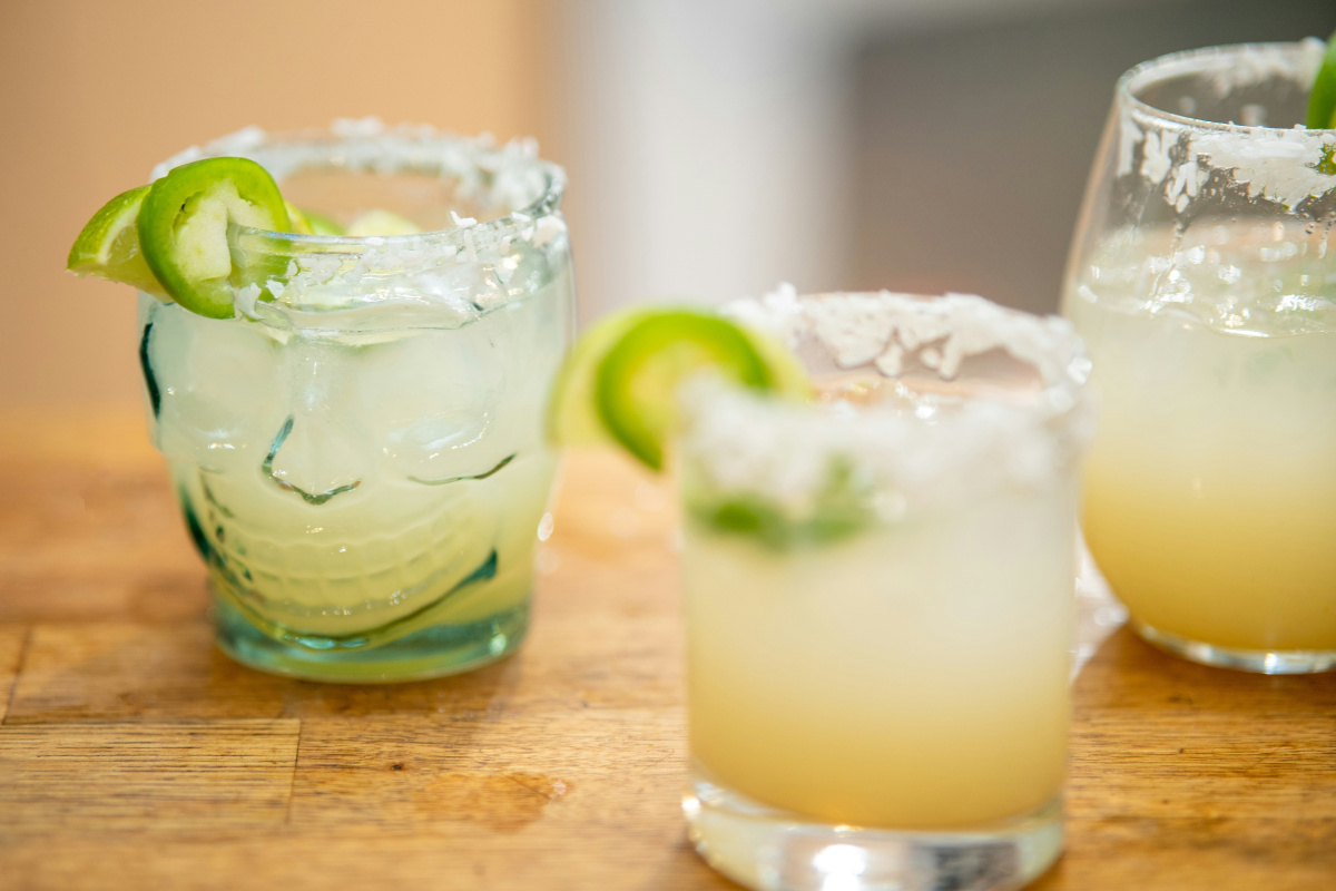Margarita &eacute;pic&eacute;s avec un bord givr&eacute; de sel sur une table en bois.