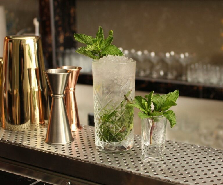 Cocktail Mojito avec menthe et glace pilée sur un comptoir de bar.
