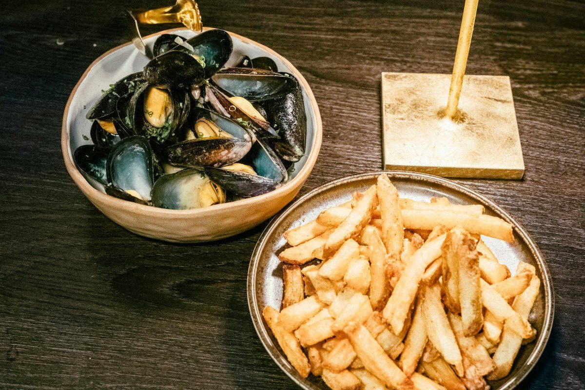 Moules marini&egrave;res frites sur une table.