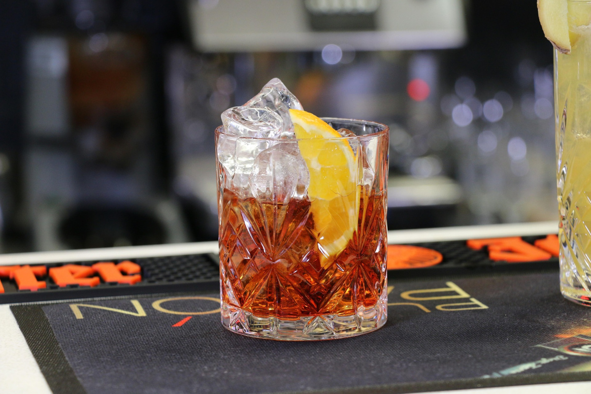 Cocktail Negroni sur glace, garni d'une tranche d'orange