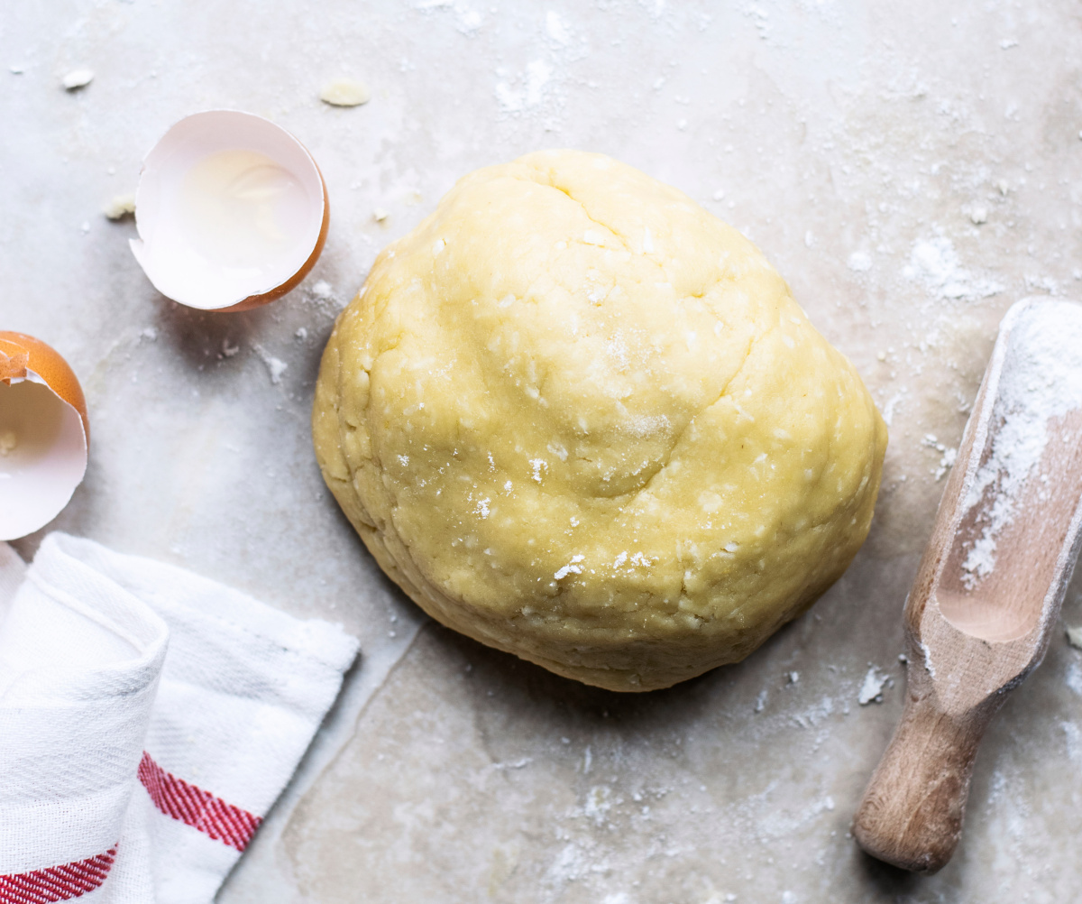 Boule de p&acirc;te bris&eacute;e sur un plan de travail farin&eacute;.