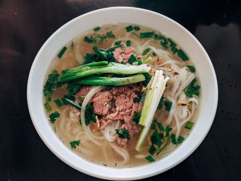 Phở vietnamienne au bœuf, nouilles et herbes fraîches.