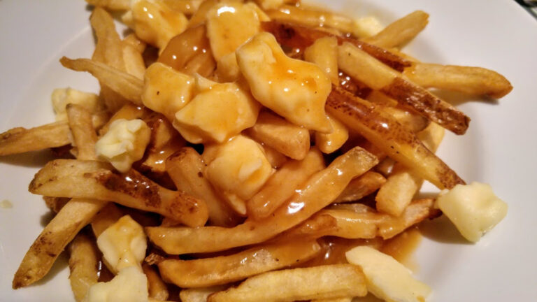Poutine classique avec frites, fromage en morceaux et sauce brune.