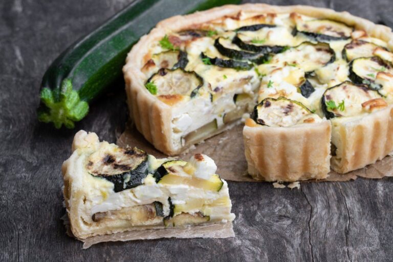 Quiche maison à la courgette et feta, avec une part coupée.