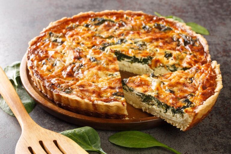 Quiche florentine dorée aux épinards, avec une part coupée.