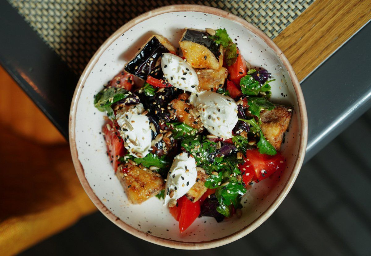 Salade d'aubergines grill&eacute;es, tomates et fromage dans un bol.