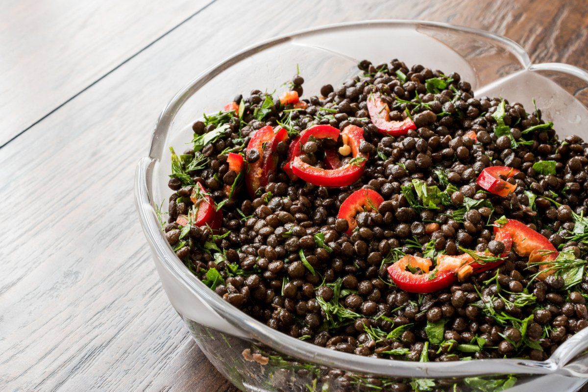 Salade de lentilles noires, poivrons rouges et herbes fra&icirc;ches.