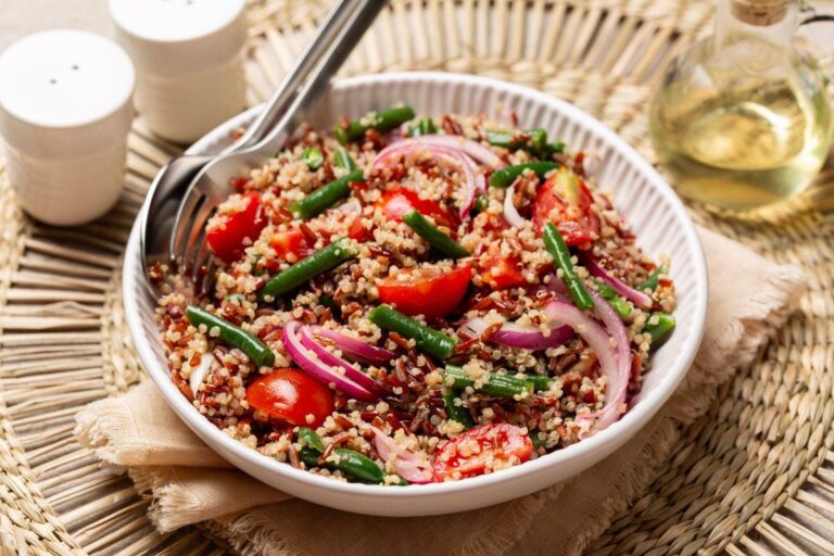 Salade de quinoa colorée avec haricots verts, tomates et oignons.