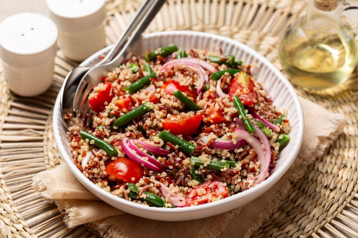 Salade de quinoa color&eacute;e avec haricots verts, tomates et oignons.