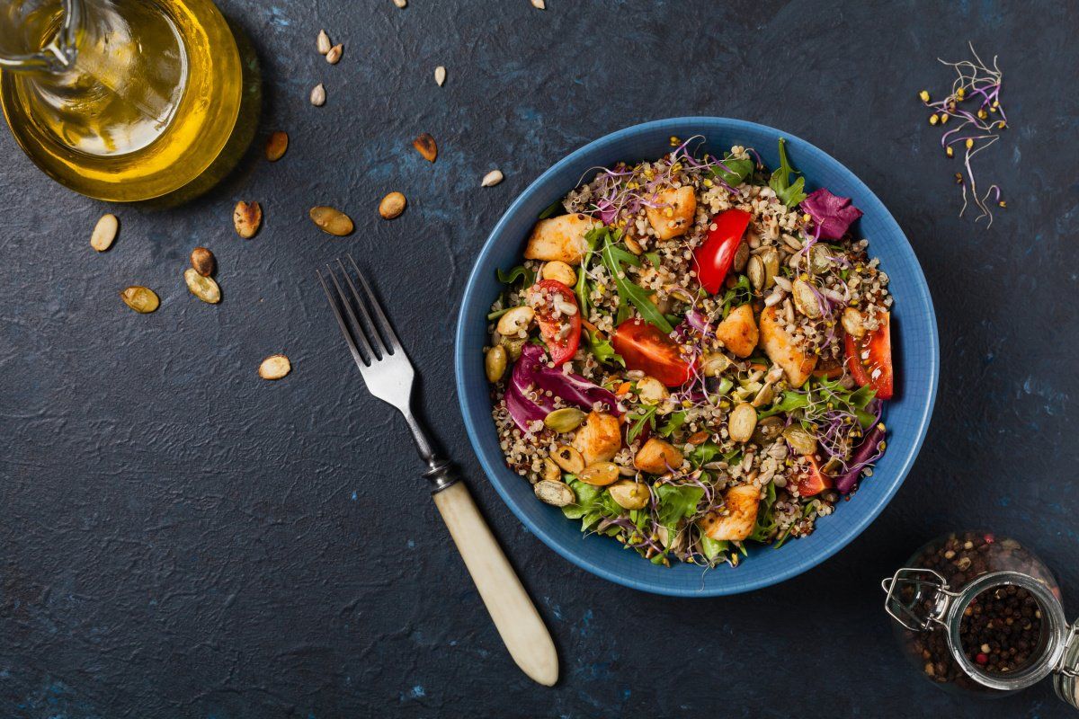 Salade color&eacute;e de quinoa et poulet dans un bol bleu.