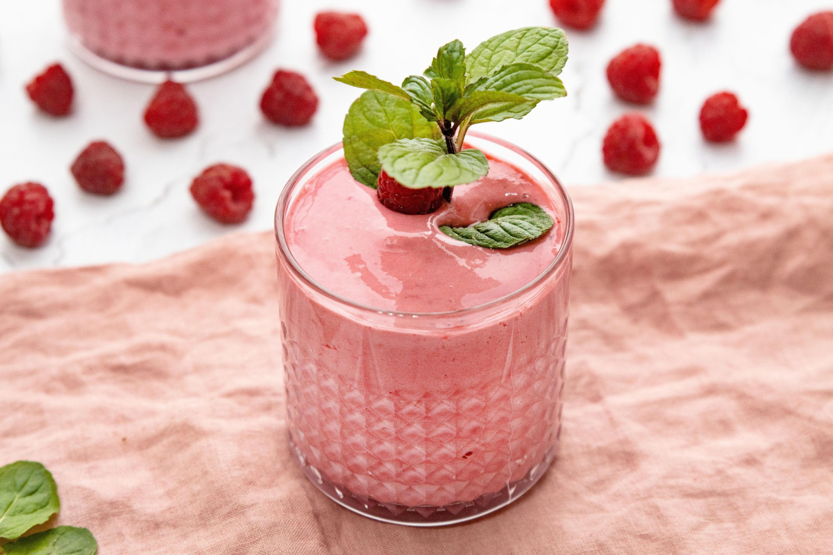 Smoothie rose &agrave; la framboise, d&eacute;cor&eacute; de menthe fra&icirc;che.