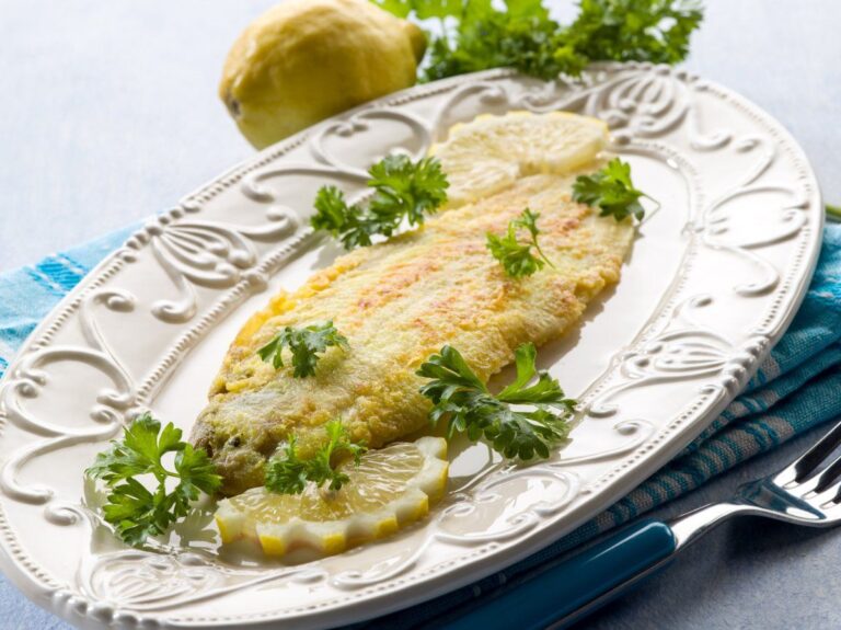 Filet de sole panée servi, décoré de persil et citron.