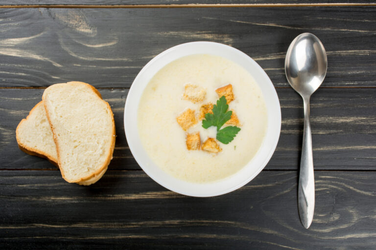 Bol de soupe au fromage crémeuse avec croûtons.