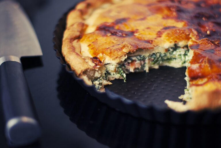 Tarte dorée au saumon et aux épinards, une part manquante.