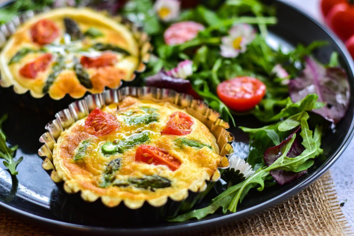 Tartelettes sal&eacute;es aux asperges et tomates servies avec une salade de roquette.