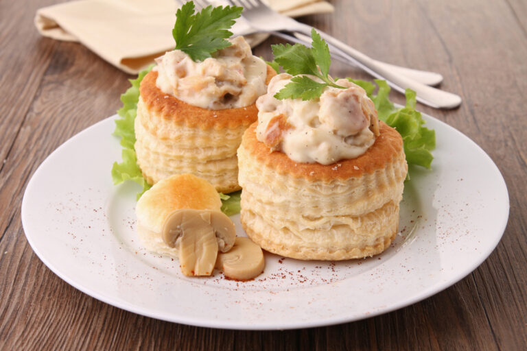 Deux vol-au-vent au poulet et champignons décorés de persil.