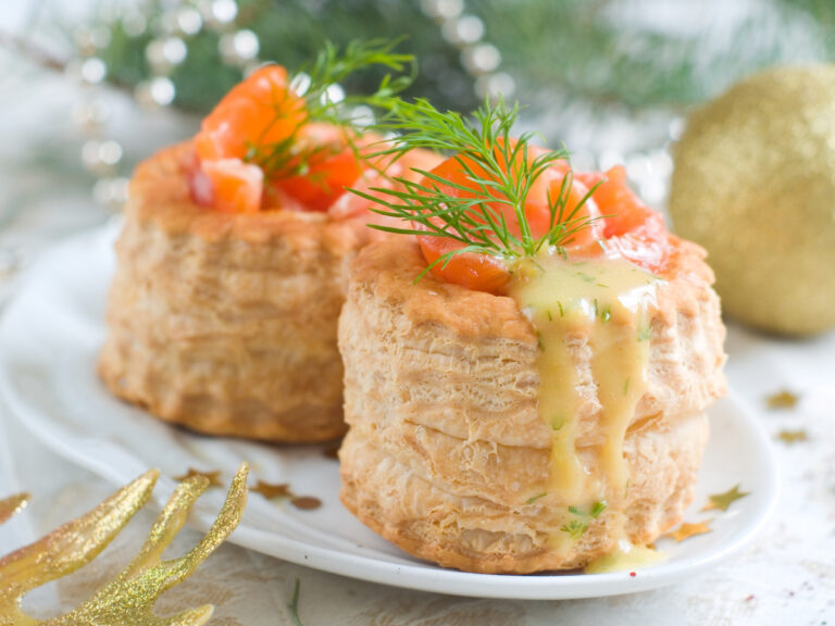 Deux vol-au-vents au saumon fumé, garnis d'aneth et de sauce.