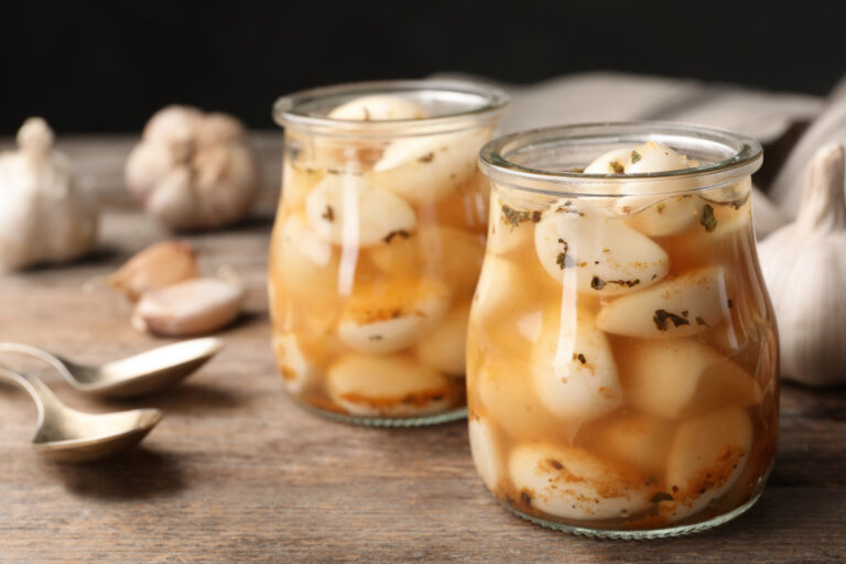 Bocaux en verre d'ail en conserve mariné aux herbes.