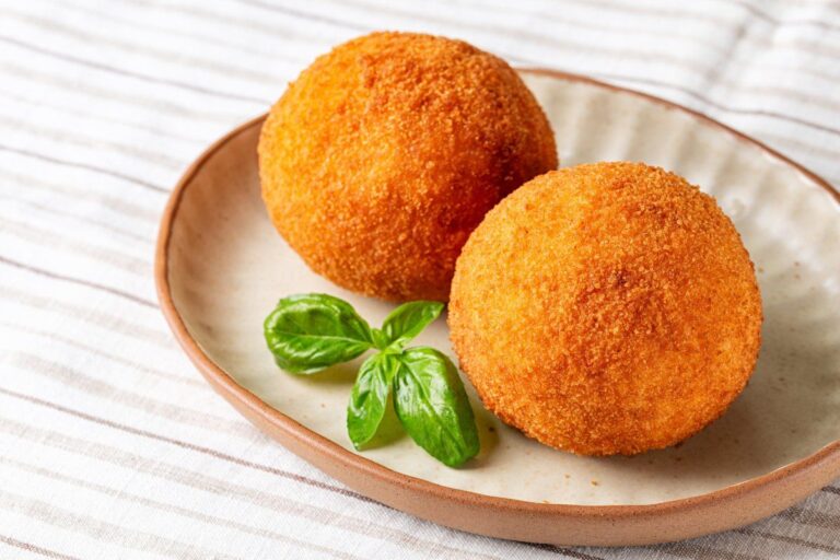 Arancini italiens dorés avec du basilic frais.