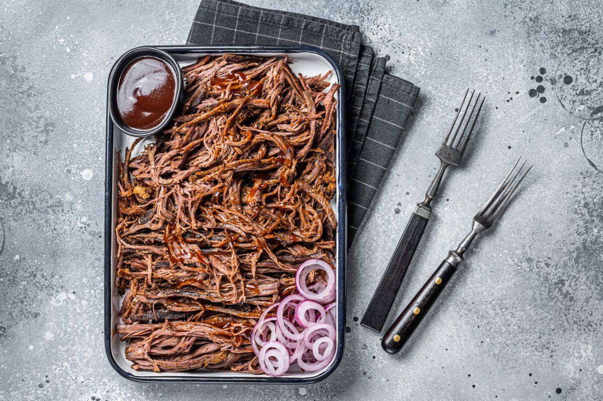 Plat de b&oelig;uf effiloch&eacute; avec sauce barbecue et oignons rouges.