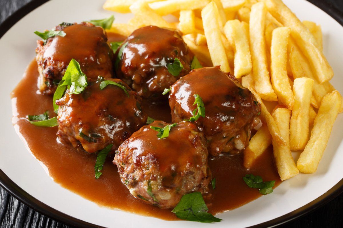 Boulets &agrave; la li&eacute;geoise en sauce, servis avec des frites.