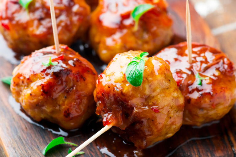 Boulettes de poulet glacées et épicées servies sur une planche.