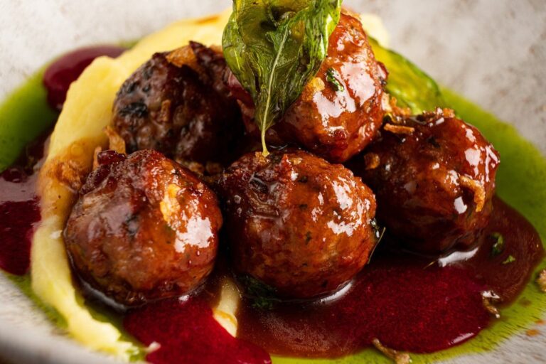 Boulettes suédoises nappées de sauce, servies avec une purée.
