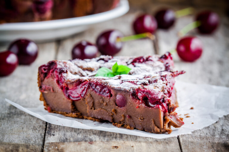 Clafoutis au chocolat et aux cerises soupoudré de sucre glace et décoré de menthe..