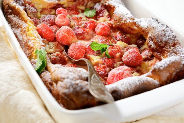 Clafoutis aux fraises doré, saupoudré de sucre glace.
