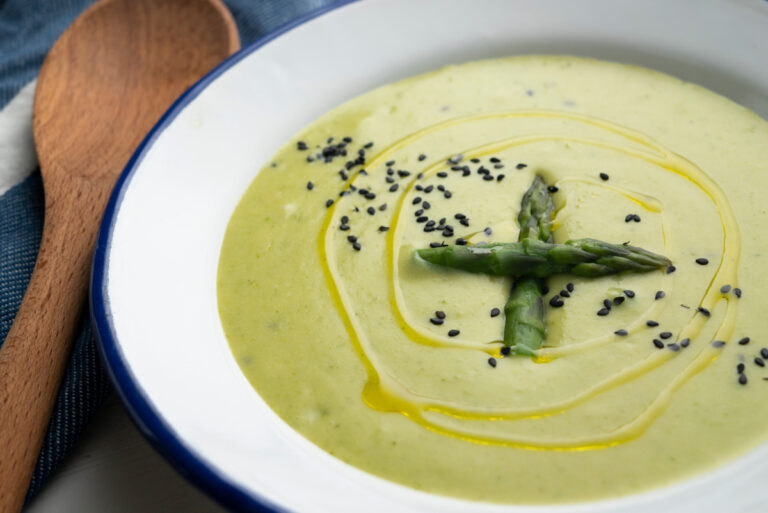 Crème d'asperges vertes avec filet d'huile d'olive et graines de sésame.