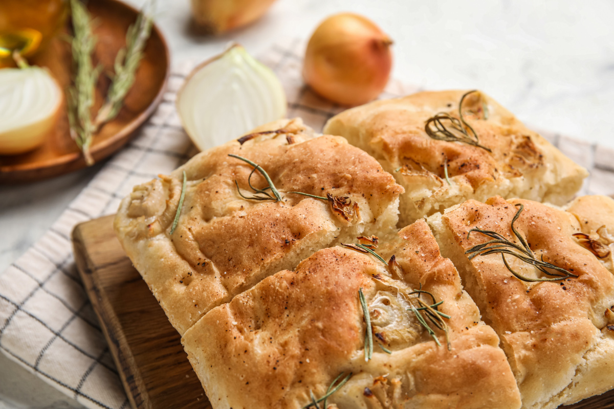 Focaccia au romarin et oignon, coup&eacute;e en parts.