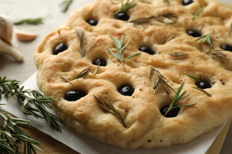 Focaccia dorée garnie d'olives noires, de romarin et d'ail.