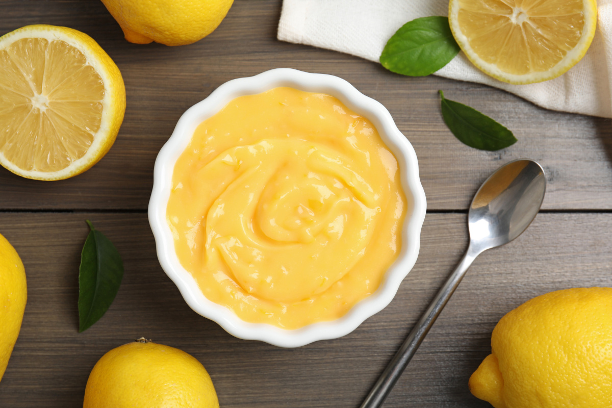 Bol de lemon curd, entour&eacute; de citrons frais.