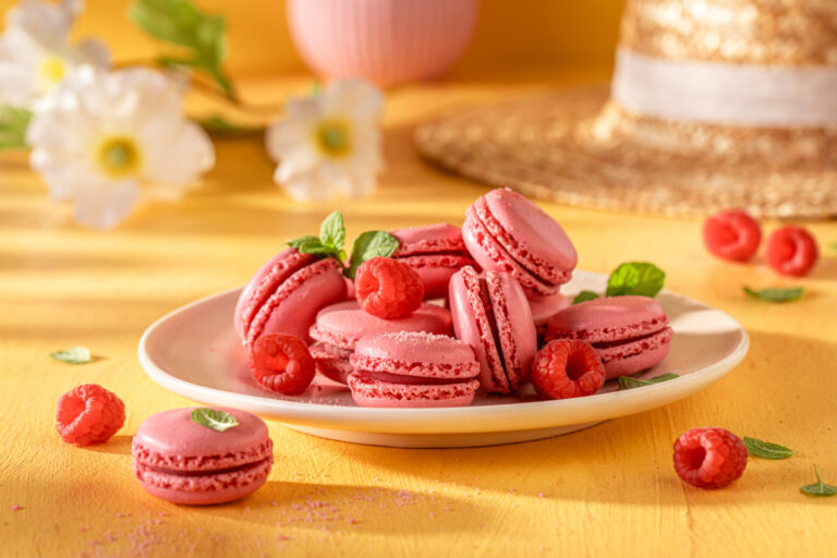 Macarons roses à la framboise décorés de feuilles de menthe.