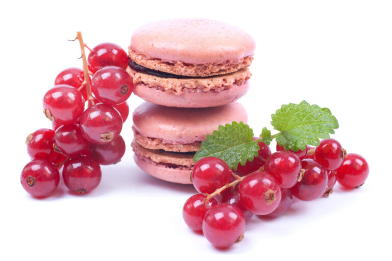 Macarons roses et des groseilles fraîches.