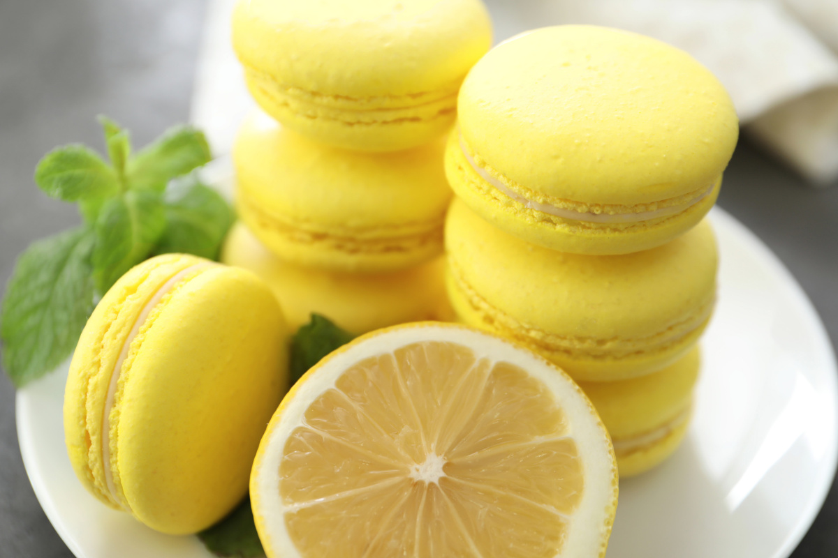 Macarons jaunes au citron avec un citron frais.