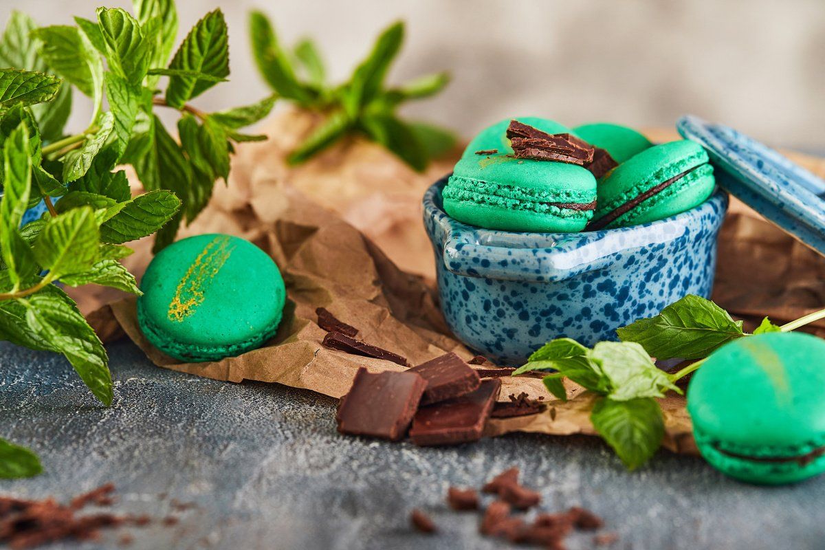 Macarons verts menthe-chocolat avec des feuilles de menthe fra&icirc;che.