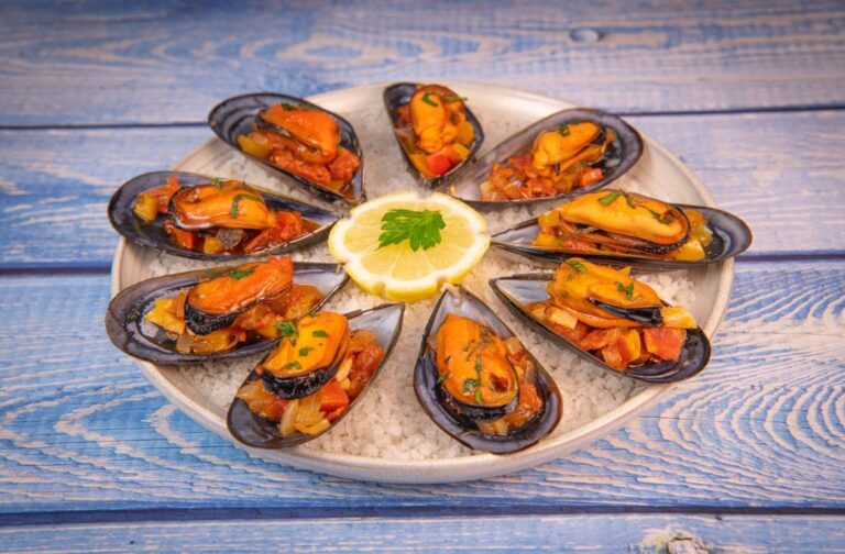 Assiette de moules à l'espagnole au chorizo servies sur un lit de sel.