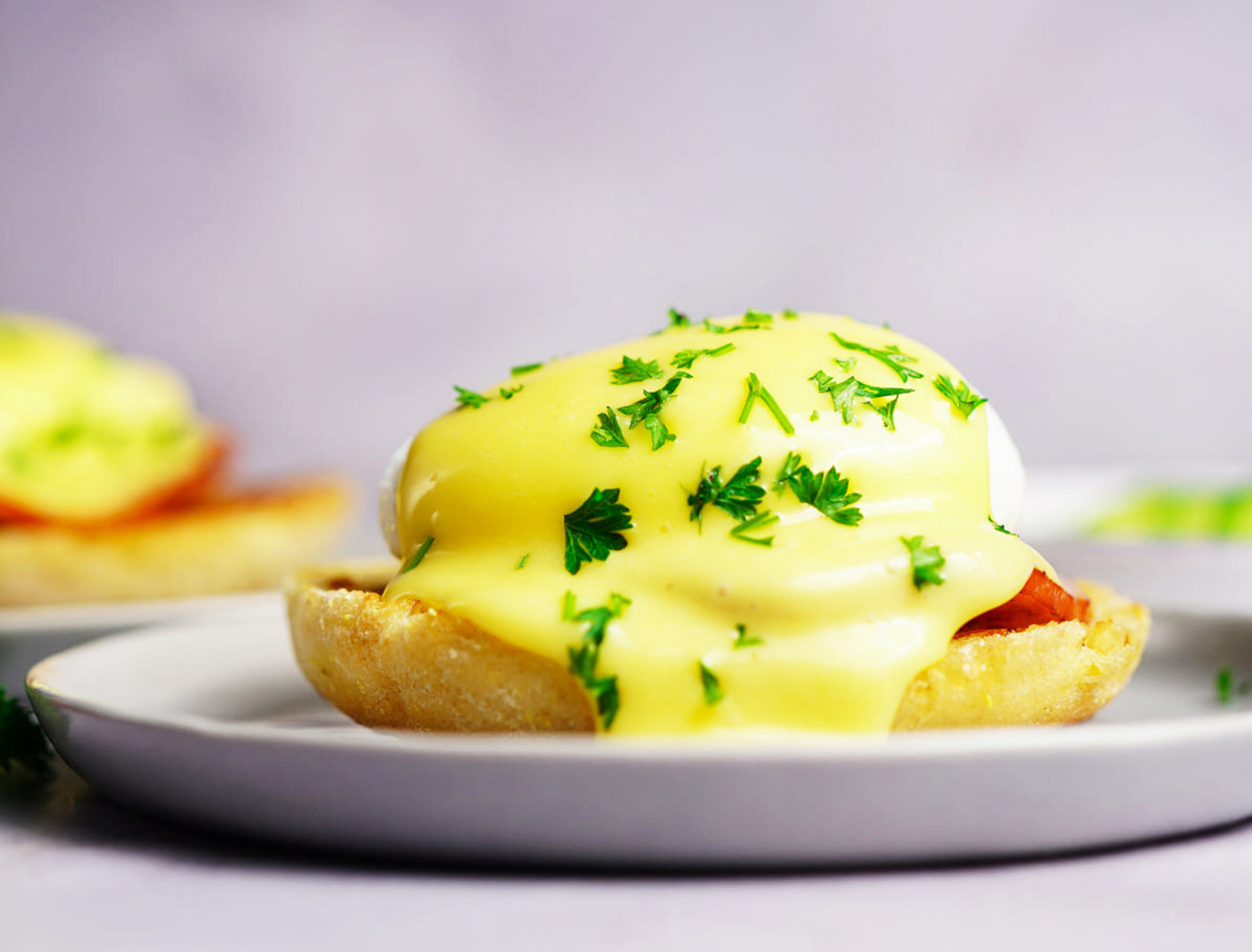 &OElig;ufs B&eacute;n&eacute;dicte napp&eacute;s de sauce hollandaise et persil pos&eacute;s sur demi muffin anglais.
