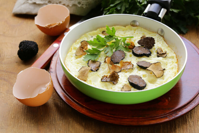 Omelette aux truffes noires et persil servie dans une poêle.