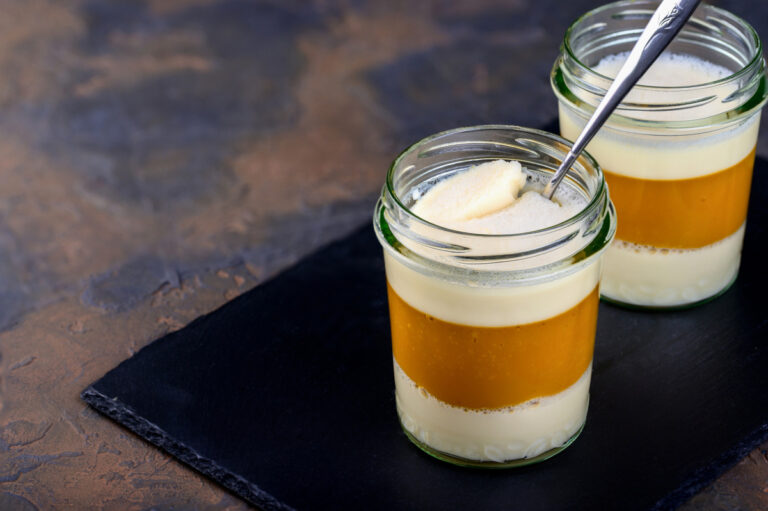 Deux verrines de panna cotta au lait de coco et à la mangue sur ardoise.