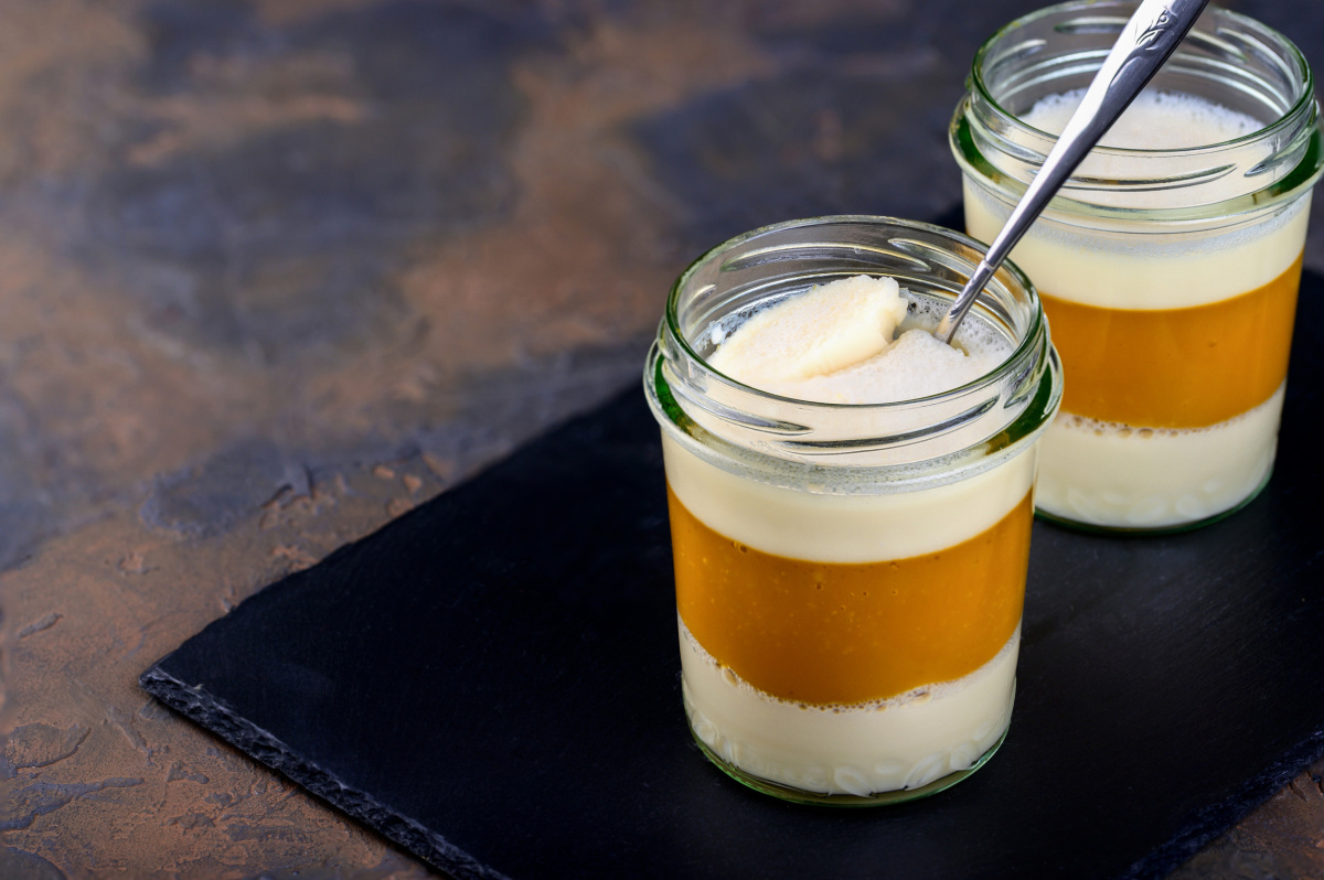 Deux verrines de panna cotta au lait de coco et à la mangue sur ardoise.