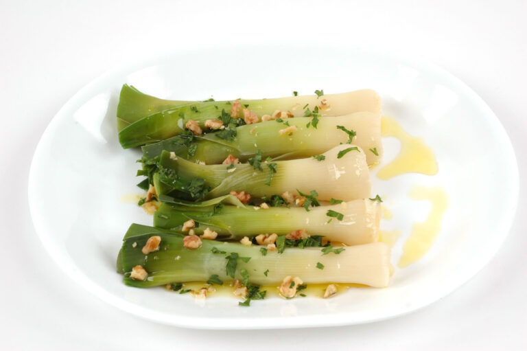 Poireaux cuits en vinaigrette avec des éclats de noix et du persil frais.