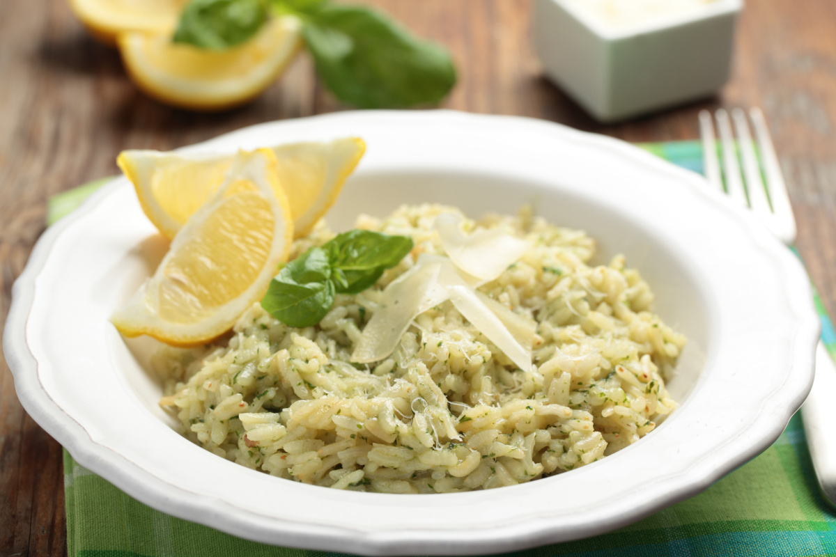 Assiette de risotto au parmesan et basilic, avec des quartiers de citron.