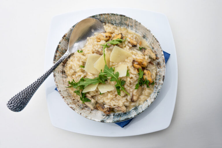 Risotto aux moules, roquette et parmesan dans un bol.