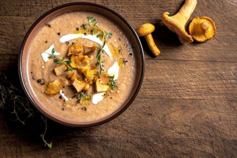 Soupe aux chanterelles avec un traite de crème, garnie de thym.