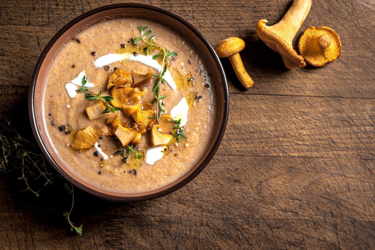 Soupe aux chanterelles avec un traite de crème, garnie de thym.